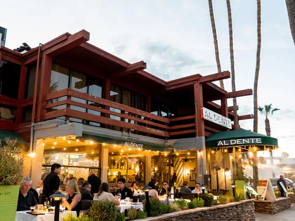 Al Dente Trattoria exterior featuring guests enjoying a meal in the evening on a gorgeous patio. 