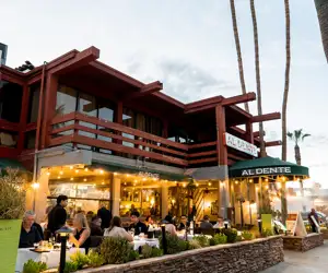 Al Dente Trattoria exterior featuring guests enjoying a meal in the evening on a gorgeous patio. 