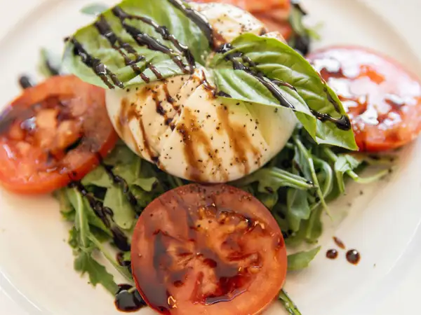 Caprese salad with ripe tomatoes, arugula and balsamic glaze at Al Dente Italian restaurant. 